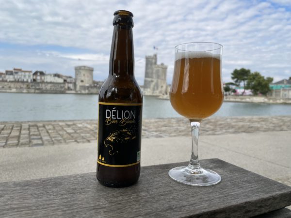 bouteille et verre de blonde Délion devant les deux tours de La Rochelle